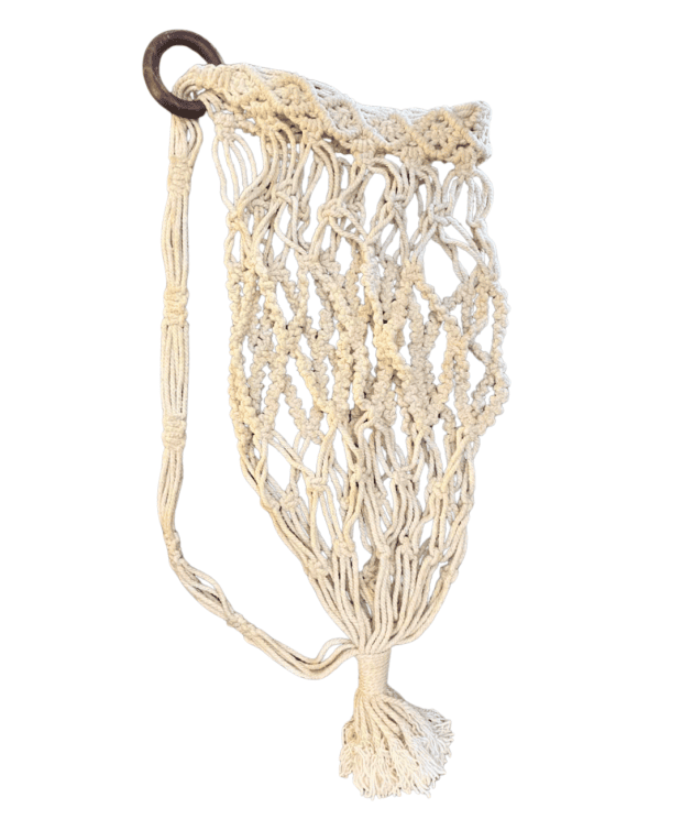 Handcrafted macramé yoga mat bag holding a rolled yoga mat.